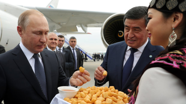 Russian President Vladimir Putin, left, and Kyrgyzstan's President Sooronbai Jeenbekov, second from right, sample a Kyrgyz traditional meal during their meeting in Bishkek, Kyrgyzstan, in March.