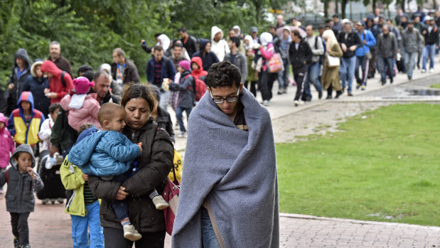 Migrants walk from the main station in Dortmund, Germany, to a hall at the height of the migrant crisis in 2015.
