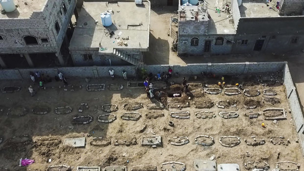 Grave diggers bury bodies at Radwan Cemetery in Aden, Yemen.