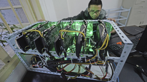 A staff member checks a bitcoin mining computer at the bitcoin mining company Landminers in southwestern China’s Chongqing Municipality.