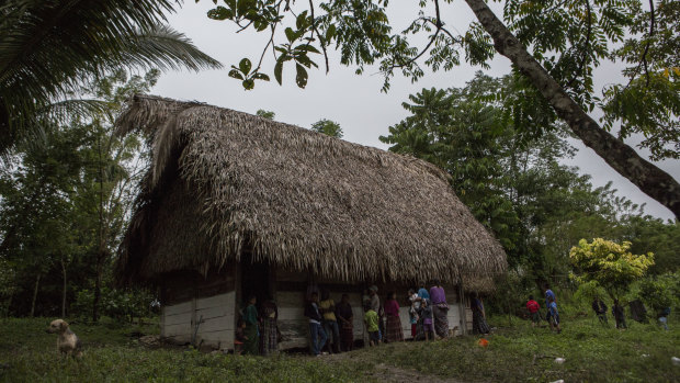 Neighbours gather around Claudia Maquin's house in Raxruha, Guatemala on Saturday, December 15.