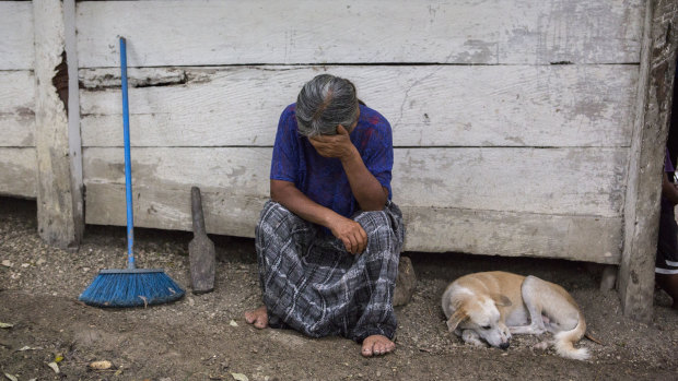 Elvira Choc, 59, Jakelin's grandmother, rests her head on her hand in front of her house in Raxruha, Guatemala.