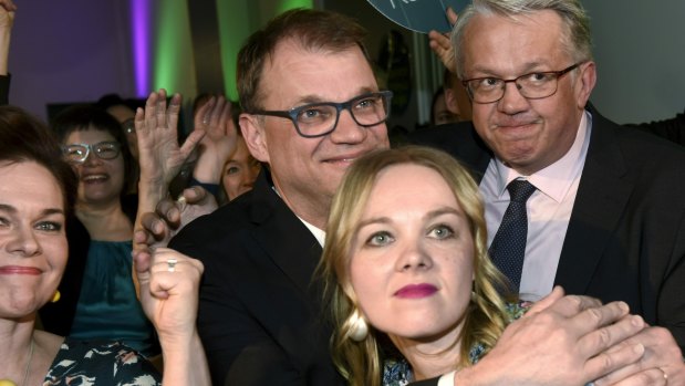 Finnish Prime Minister and Chairman of Centre Party Juha Sipila, second from centre, reacts to the first results in Helsinki on Sunday.