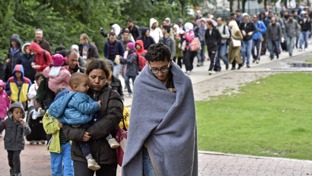 Migrants walk from the main station in Dortmund, Germany, to a reception hall on arrival in 2015.