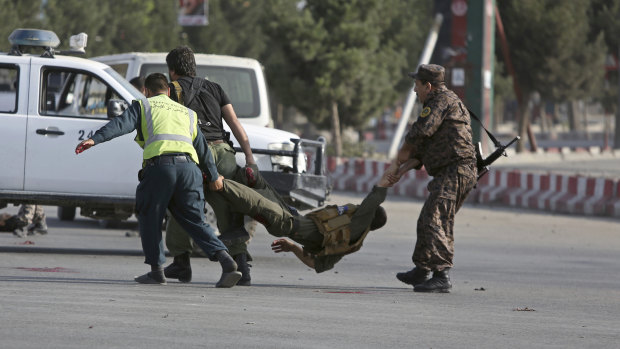 Afghan security personnel carry an injured officer after an attack near the Kabul Airport, in Kabul, Afghanistan on July 22.