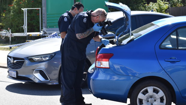 Police examine a car outside a Kewdale property where a woman died on Monday evening.
