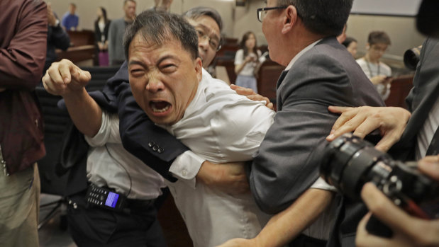 Pro-democracy lawmaker Wu Chi-Wai is restrained at the Legislative Council in May.