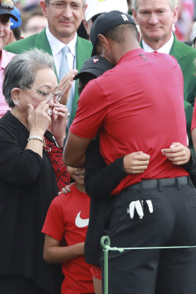 Tiger Woods embraces his daughter Sam and son Charlie, as his mother Kultida wipes away tears.