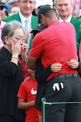 Tiger Woods embraces his daughter Sam and son Charlie, as his mother Kultida wipes away tears.