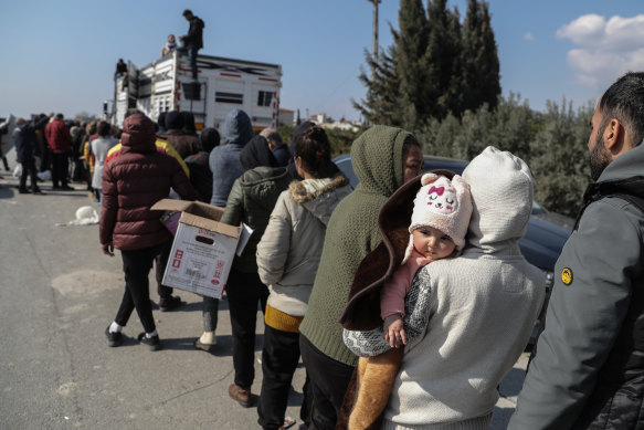 People in Turkey queue to receive food and goods on Monday. 