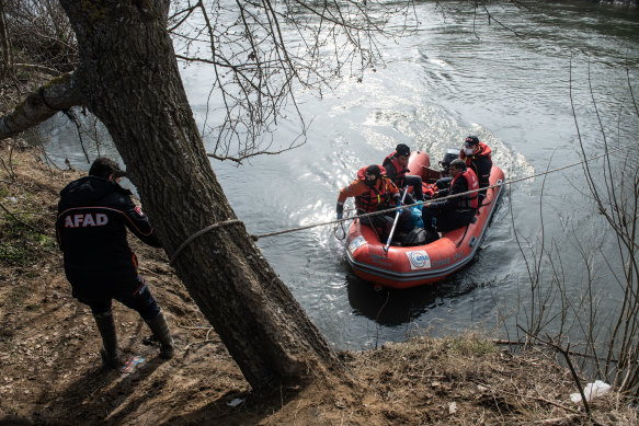 Refugees and migrants are rescued from an island in the middle of the Evros river on Sunday. They had been stuck there for two days after trying to cross from Turkey to Greece.