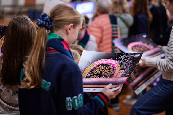 A young Vixens fan admires the team’s premiership poster.
