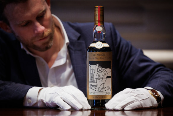 Jonny Fowle, Sotheby’s global head of spirits, unveils a bottle of The Macallan 1926, the world’s most expensive whisky.