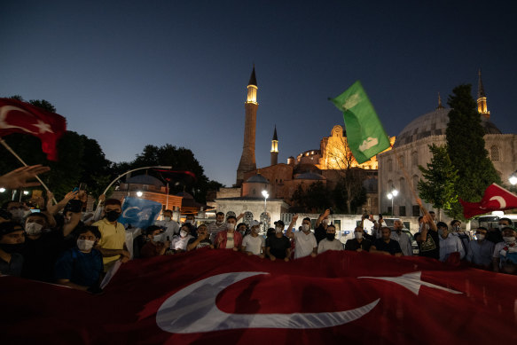 People wave flags and chant slogans after the evening prayers outside Istanbul's famous Hagia Sophia on after the court decision in Istanbul, Turkey. 