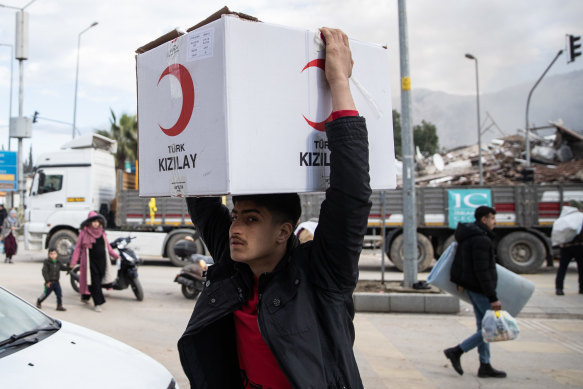 A man carries an aid box in Hatay, Turkey. 