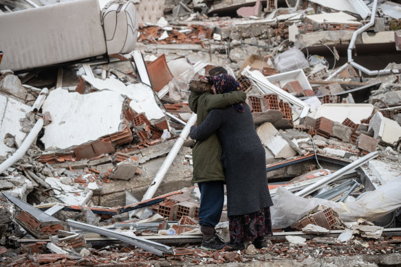 Women hug each other near the collapsed building in Hatay, Turkey.