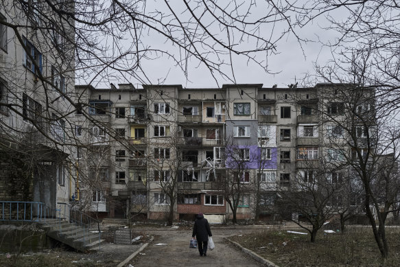 A civilian walks among heavily damaged residential buildings in Soledar.