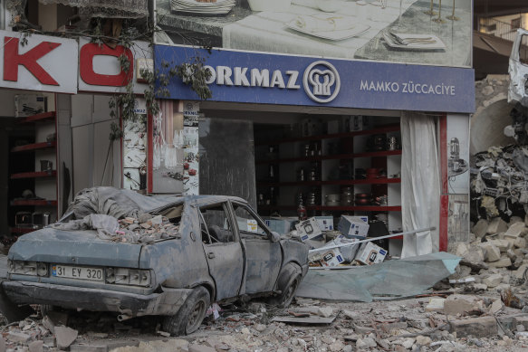 A destroyed car and shop in Hatay, Turkey on February 20. The area was hit with another two earthquakes late on Monday (Tuesday AEDT).