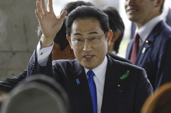 Japanese Prime Minister Fumio Kishida waves as he visits a port in Wakayama.