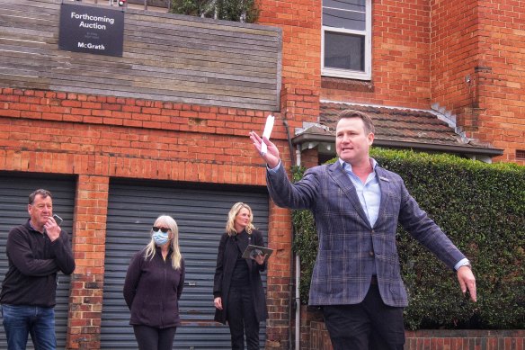 Auctioneer Josh Stirling accepts bids for a property on Brighton Road, St Kilda on Sunday. The two-bedroom apartment sold for $891,000, which was $100,000 above reserve.