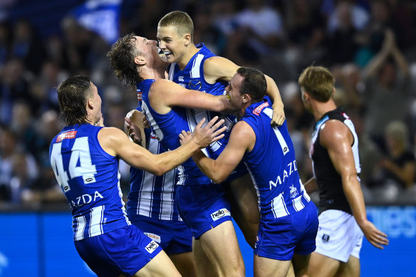 Tom Powell is swamped by teammates as he celebrates his first goal in the AFL.