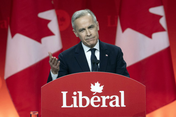 Liberal Leader Mark Carney gestures to Prime Minister Justin Trudeau as he delivers his victory speech.