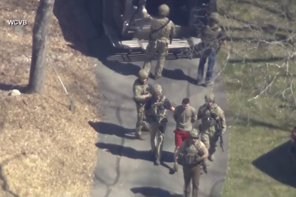 This image made from video provided by WCVB-TV, shows Jack Teixeira, in T-shirt and shorts, being taken into custody.
