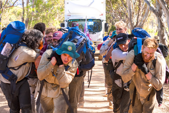 Manly players drag a five-tonne truck, loaded with another two tonnes of equipment, through the bush near Mudgee.