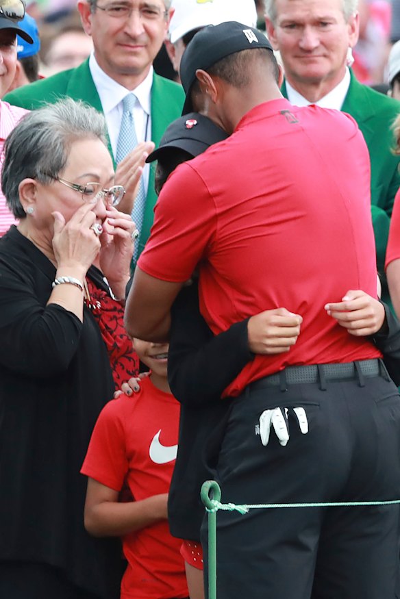 Tiger Woods embraces his daughter Sam and son Charlie, as his mother Kultida wipes away tears.