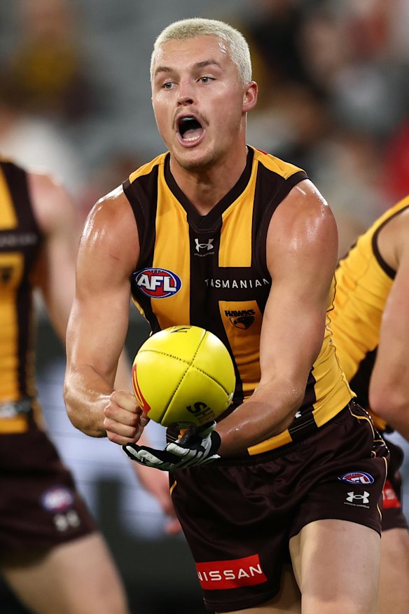 Jack Ginnivan of the Hawks handpasses the ball.