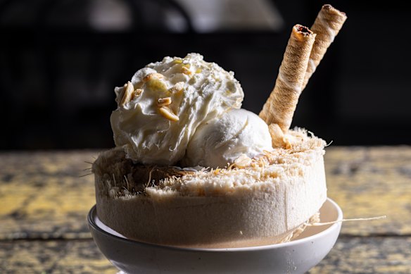 A coconut ice-cream sundae is served in a coconut shell.