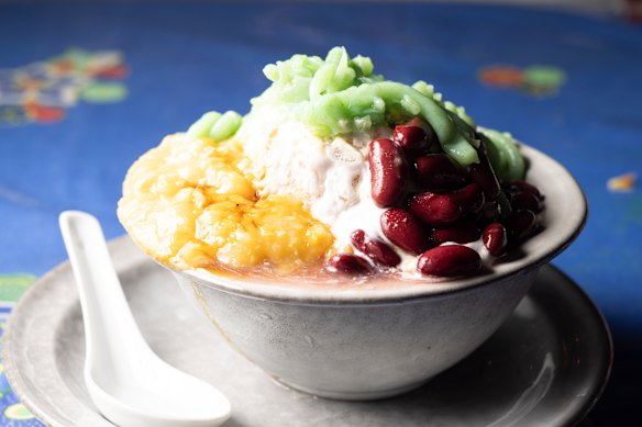 Cendol Biasa, gelo picado embebido em xarope de açúcar de palma e recheado com creme de milho, feijão e rabiscos de geleia de pandan.