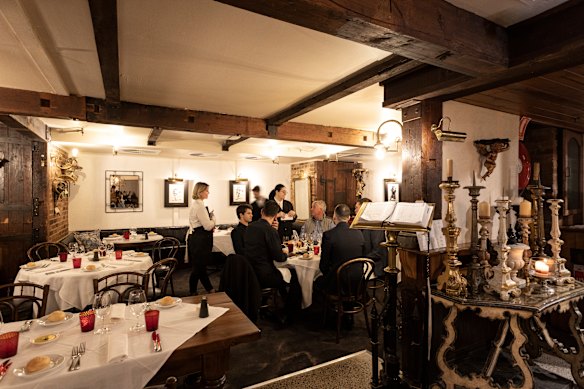 Lamplit, mirrored and framed by timber beams, the restaurant is a collector’s den.