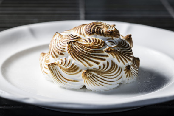 Torched meringue conceals the bombe Alaska’s raspberry sorbet centre.