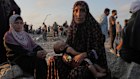 Somoud Wahdan sits with her child in the northern Gaza Strip, waiting for humanitarian aid trucks to arrive.