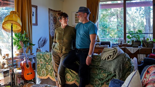 Kate Holden and Tim Flannery in the open-plan living area, where they like to entertain. It is filled with books, plants and numerous op-shop finds. Suspended above them is a wooden-framed canoe handcrafted by Peter Ingram-Jones.