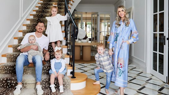 Tom Cahill, Georgia Bardoel and their young family on the staircase of their dream home.