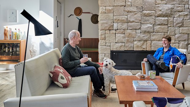 Patrick and Elizabeth Mitchell in their living room with its stone fireplace. The vintage suite is from Metro Road Trading.