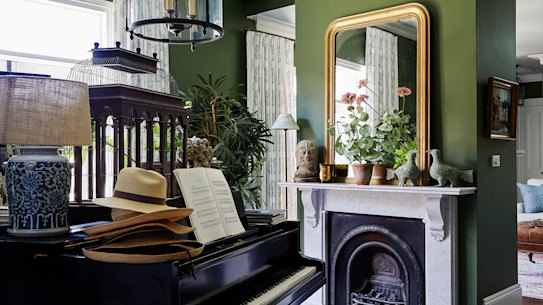 Baker had the baby grand piano she played as a child in England shipped to Australia. This room also features her collection of bird cages, plus a pendant light and vintage rug from Isla Design.