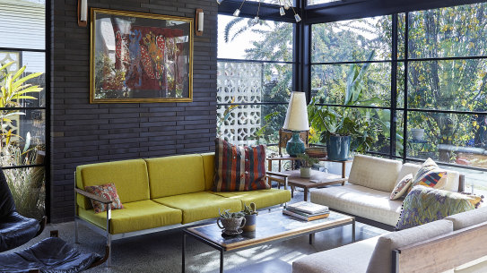 Metal-framed, floor-to-ceiling glass sliding doors and windows are a feature of the home’s brick and steel extension. The painting, titled Frog Spirit Dreaming, is by Alan Dowler Kamara.