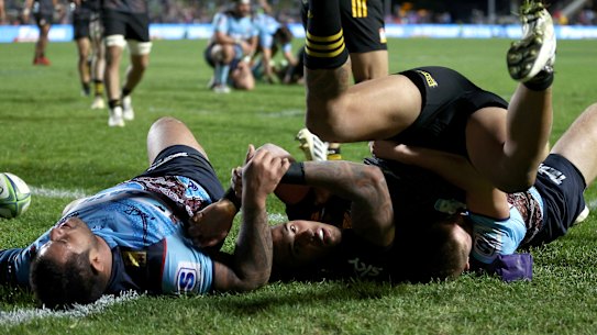 Sean Wainui scatters Waratahs defenders on the way to the line.