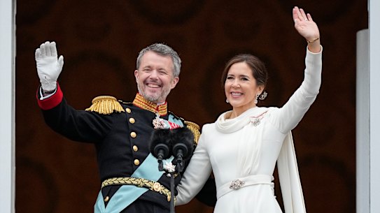 Denmark’s King Frederik X and Queen Mary wave from the balcony of Christiansborg Palace.
