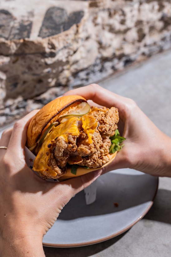 The PCP Burger with fried chicken, pickles and American cheese.