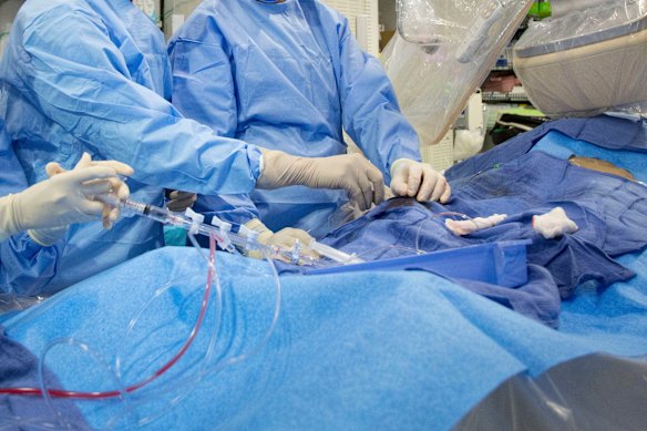 Doctors perform an angioplasty. Through a blood vessel in the groin, a tube is guided to a blockage in the heart. A tiny balloon is then inflated to flatten the clog, and a mesh tube called a stent is inserted to prop the artery open. 
