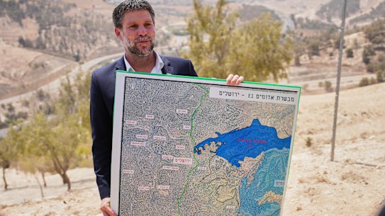 Israeli Finance Minister Bezalel Smotrich holds a map showing the E1 settlement project during a press conference in the Israeli-occupied West Bank on Thursday.