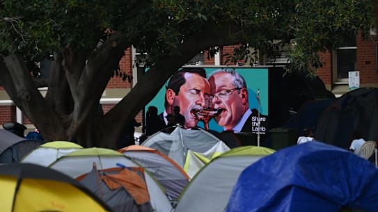 A billboard ad featuring Mark McGowan goes by ‘tent city’ in Fremantle as the camp is closed and homeless people are bussed to temporary hotel accommodation. 