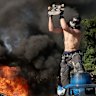 A protester damages a Waymo vehicle at Los Angeles St. and Arcadia in Los Angeles, CA on June 8, 2025.