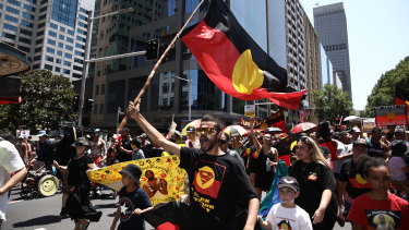 Taking to the streets:  Invasion Day Rally in Sydney on Saturday. David Dungay 's nephew Paul Dungay waves the Aboriginal flag.