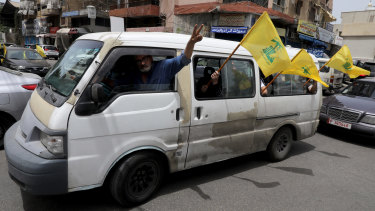 Hezbollah supporters wave flags in Beirut. The organisation has lost its majority in the Lebanese parliament.