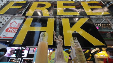 A miniature replica of the Goddess of Democracy stands in front of a 'Free HK' sign near Victoria Park.